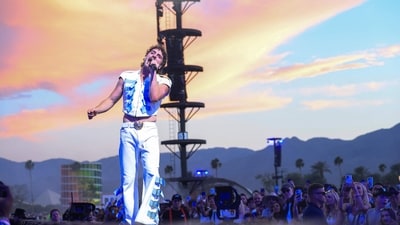 BestDressed: Benson Boone lit up the Coachella stage in two dazzling custom looks by Dolce & Gabbana. His opening ensemble included a sleek cotton gabardine sleeveless jacket and wide-leg trousers, accented with gold buckles and buttons, complete with a statement Devotion Heart belt. For his second look, he amped up the drama in a shimmering lurex bodysuit and flared pants, both covered in Swarovski crystals, topped with a regal velvet cape trimmed in faux fur and completed the look with bijoux jewellery. (Photo by VALERIE MACON / AFP) / RESTRICTED TO EDITORIAL USE) BestDressed: Benson Boone lit up the Coachella stage in two dazzling custom looks by Dolce & Gabbana. His opening ensemble included a sleek cotton gabardine sleeveless jacket and wide-leg trousers, accented with gold buckles and buttons, complete with a statement Devotion Heart belt. For his second look, he amped up the drama in a shimmering lurex bodysuit and flared pants, both covered in Swarovski crystals, topped with a regal velvet cape trimmed in faux fur and completed the look with bijoux jewellery. (Photo by VALERIE MACON / AFP) / RESTRICTED TO EDITORIAL USE)