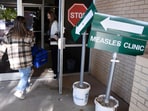 Health department staff members enter the Andrews County Health Department measles clinic carrying doses of the measles, mumps and rubella vaccine, Tuesday, April 8, 2025, in Andrews, Texas. Health department staff members enter the Andrews County Health Department measles clinic carrying doses of the measles, mumps and rubella vaccine, Tuesday, April 8, 2025, in Andrews, Texas.
