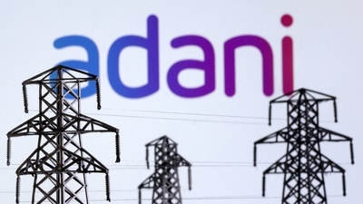 Electric power transmission pylon miniatures and Adani Green Energy logo are seen in this illustration taken, December 9, 2022. (Dado Ruvic/Reuters)