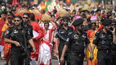 Folk music, traditional cuisine, vibrant processions, and heartfelt "Shubho Noboborsho" (Happy New Year) greetings all grace the day for Bengalis worldwide. In pic: Security personnel stand guard as people march down a street during celebrations marking Bengali New Year. (AFP) Folk music, traditional cuisine, vibrant processions, and heartfelt "Shubho Noboborsho" (Happy New Year) greetings all grace the day for Bengalis worldwide. In pic: Security personnel stand guard as people march down a street during celebrations marking Bengali New Year. (AFP)
