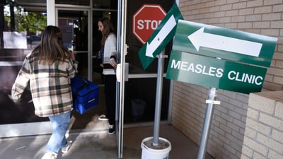 Health department staff members enter the Andrews County Health Department measles clinic carrying doses of the measles, mumps and rubella vaccine, Tuesday, April 8, 2025, in Andrews, Texas. (AP) Health department staff members enter the Andrews County Health Department measles clinic carrying doses of the measles, mumps and rubella vaccine, Tuesday, April 8, 2025, in Andrews, Texas. (AP)