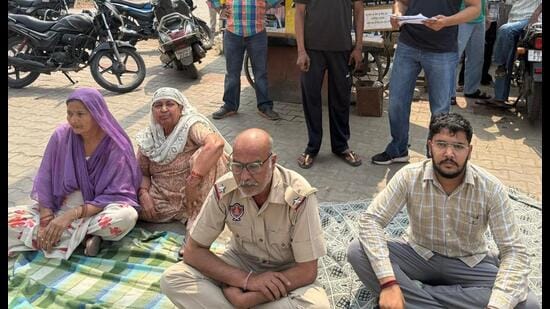 ASI Rakesh Kumar and his relatives during a protest outside the division number 2 police station in Patiala on Tuesday. (HT photo)