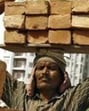 A labourer stacks bricks on his head at the construction site. (Reuters File Photo)