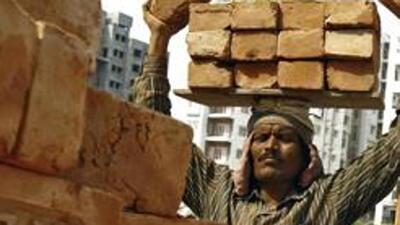 A labourer stacks bricks on his head at the construction site. (Reuters File Photo) A labourer stacks bricks on his head at the construction site. (Reuters File Photo)
