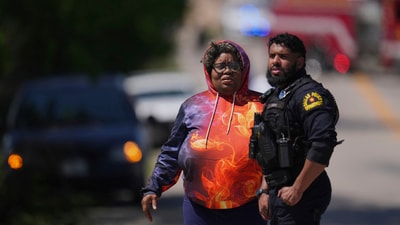 A woman carried a child as she and a student of Wilmer-Hutchins High School leave after authorities reported the campus had been secured after shooting incident. (AP Photo/Julio Cortez) (AP) A woman carried a child as she and a student of Wilmer-Hutchins High School leave after authorities reported the campus had been secured after shooting incident. (AP Photo/Julio Cortez) (AP)