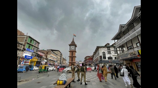 Police personnel stand guard near the Ghanta Ghar on a cloudy day, in Srinagar, on Wednesday. (PTI)