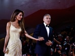 George Clooney and Amal Clooney walk on the red carpet during arrivals for the movie 'Wolfs'.