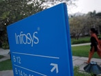 FILE PHOTO: An employees walks past a signage board in the Infosys campus at the Electronics City IT district in Bangalore, February 28, 2012. 