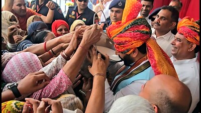 Haryana chief minister Nayab Singh Saini drinks milk directly from a bucket at Kiloi village in Rohtak district on Friday. (Manoj Dhaka/HindustanTimes)