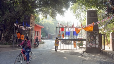 A woman passes on a cycle at the JNU gate. The notices warn that “any future complaints or violations will result in your immediate eviction from the hostel without prior notice”. (HT File) A woman passes on a cycle at the JNU gate. The notices warn that “any future complaints or violations will result in your immediate eviction from the hostel without prior notice”. (HT File)