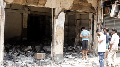 People stand near the charred remains of a building at Beldanga area of Dhuliyan, Samserganj days after violence broke out during a protest against the Waqf (Amendment) Act 2025, in Murshidabad on Thursday. (Saikat Paul/ANI)