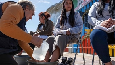 Mexico: On April 17, 2025, as part of Holy Week observances, a volunteer participated in the "Washing of the Feet" ceremony at the Mexico-US border in Playas de Tijuana, Baja California State, Mexico. Organised by the Coalition for the Defence of Migrants, the poignant ritual involved washing a migrant's feet. ( Photo by Guillermo Arias / AFP) Mexico: On April 17, 2025, as part of Holy Week observances, a volunteer participated in the "Washing of the Feet" ceremony at the Mexico-US border in Playas de Tijuana, Baja California State, Mexico. Organised by the Coalition for the Defence of Migrants, the poignant ritual involved washing a migrant's feet. ( Photo by Guillermo Arias / AFP)
