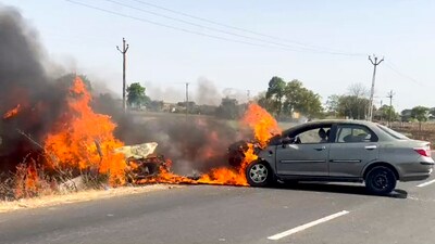 A car catches fire after colliding with another car in an accident on the Sardhar-Bhadla road near Rajkot, Saturday, April 19, 2025. (PTI)