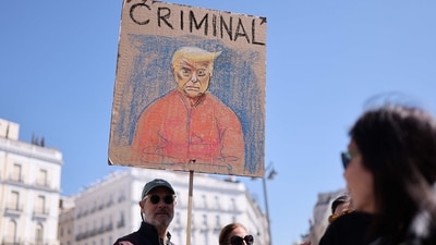 A protestor holds a draw depicting US President Donal Trump bearing the writing 'Criminal' during an anti-Trump protest called by Democrats Abroad organisation in Madrid's Puerta del Sol on March 29, 2025. (AFP FILE)