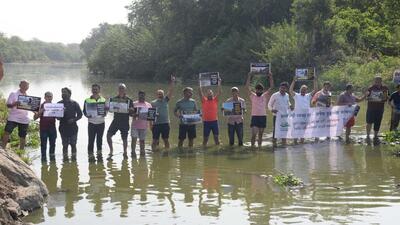 Around 25 citizens and environmentalists on Sunday morning protested against the ongoing riverfront development (RFD) project at Mula riverbed near Pimple Nilakh. (HT) Around 25 citizens and environmentalists on Sunday morning protested against the ongoing riverfront development (RFD) project at Mula riverbed near Pimple Nilakh. (HT)
