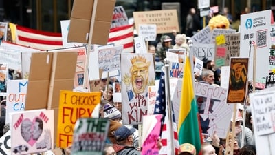 Demonstrators hold up signs during a rally titled "day of action" protest against US President Donald Trump's policies and executive actions, in downtown Chicago, Illinois, on April 19, 2025. (AFP) Demonstrators hold up signs during a rally titled "day of action" protest against US President Donald Trump's policies and executive actions, in downtown Chicago, Illinois, on April 19, 2025. (AFP)