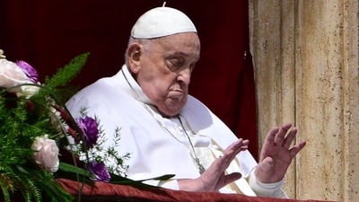 Meanwhile, Pope Francis waves from the main balcony of St. Peter's basilica during the Urbi et Orbi message and blessing to the city and the world as part of Easter celebrations, at St Peter's square in the Vatican on April 20, 2025. (Photo by Tiziana FABI / AFP) (AFP) Meanwhile, Pope Francis waves from the main balcony of St. Peter's basilica during the Urbi et Orbi message and blessing to the city and the world as part of Easter celebrations, at St Peter's square in the Vatican on April 20, 2025. (Photo by Tiziana FABI / AFP) (AFP)