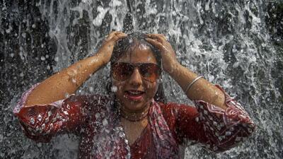 A tourist enjoys at the waterfall on a hot summer day, at Rock Garden in Chandigarhon Monday. (PTI)