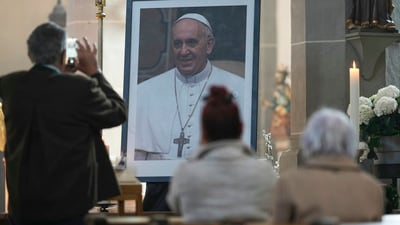 A man takes pictures of a photograph with Pope Francis placed at Saint Philip and Saint James Catholic church in Altoetting, Germany, Monday, April 21, 2025. (AP Photo/Matthias Schrader) (AP) A man takes pictures of a photograph with Pope Francis placed at Saint Philip and Saint James Catholic church in Altoetting, Germany, Monday, April 21, 2025. (AP Photo/Matthias Schrader) (AP)