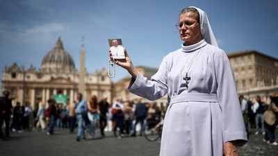 A nun holds an image of Pope Francis near St Peter's square, after the death of Pope Francis was announced by the Vatican, as seen from Rome, Italy, April 21, 2025. REUTERS/Guglielmo Mangiapane     TPX IMAGES OF THE DAY (REUTERS)