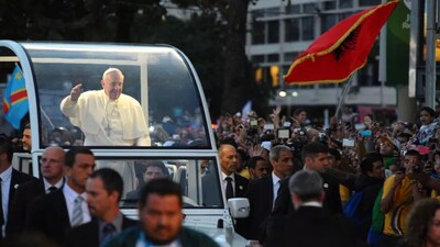 Pope Francis waves to the crowd while riding in the Popemobile during World Youth Day in Rio de Janeiro, Brazil, in 2013. Sebastien Desarmaux/Getty Images. 