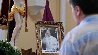 A believer mourns in front of a portrait of the late Pope Francis at Moscow's Cathedral of Virgin Mary Immaculate Conception on April 21, 2025. (Photo by Alexander NEMENOV / AFP) (AFP) A believer mourns in front of a portrait of the late Pope Francis at Moscow's Cathedral of Virgin Mary Immaculate Conception on April 21, 2025. (Photo by Alexander NEMENOV / AFP) (AFP)