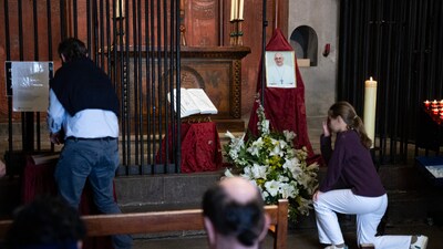 A girl kneels near an image of Pope Francis in the Chapel of Saint Lucia in Barcelona's cathedral, on April 21, 2025. (Photo by Josep LAGO / AFP) (AFP) A girl kneels near an image of Pope Francis in the Chapel of Saint Lucia in Barcelona's cathedral, on April 21, 2025. (Photo by Josep LAGO / AFP) (AFP)