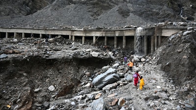 &nbsp;People walk on a blocked Srinagar- Jammu national highway after a cloudbursts at Ramban,on 21 April 2025. (Hindustan Times)
