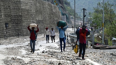 People walk on a blocked Srinagar- Jammu national highway after a cloudbursts at Ramban,on 21 April 2025. (Hindustan Times)