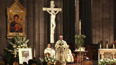 Archbishop Peter Comensoli (C) holds mass as a photo of the late Pope Francis is displayed at St Patrick's Cathedral in Melbourne on April 22, 2025. Pope Francis died of a stroke, the Vatican announced hours after the death on April 21 of the 88-year-old reformer who inspired devotion but riled traditionalists during 12 years leading the Catholic Church. (AFP) Archbishop Peter Comensoli (C) holds mass as a photo of the late Pope Francis is displayed at St Patrick's Cathedral in Melbourne on April 22, 2025. Pope Francis died of a stroke, the Vatican announced hours after the death on April 21 of the 88-year-old reformer who inspired devotion but riled traditionalists during 12 years leading the Catholic Church. (AFP)