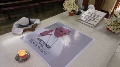 A Catholic nun of the Missionaries of Charity, the order founded by Saint Teresa, prays as a portrait of Pope Francis, placed over the saint’s tomb following his death, in Kolkata, India, Tuesday, April 22, 2025. (AP Photo/Bikas Das) A Catholic nun of the Missionaries of Charity, the order founded by Saint Teresa, prays as a portrait of Pope Francis, placed over the saint’s tomb following his death, in Kolkata, India, Tuesday, April 22, 2025. (AP Photo/Bikas Das) 
