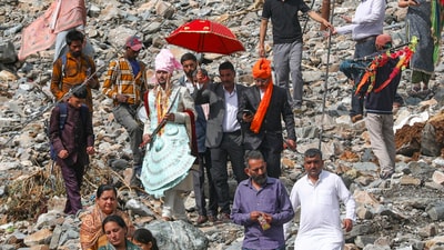 A groom along with his relatives walks towards his destination after roads were blocked by debris following heavy rain trigged landslides and flash flood, in Ramban district. (PTI) A groom along with his relatives walks towards his destination after roads were blocked by debris following heavy rain trigged landslides and flash flood, in Ramban district. (PTI)