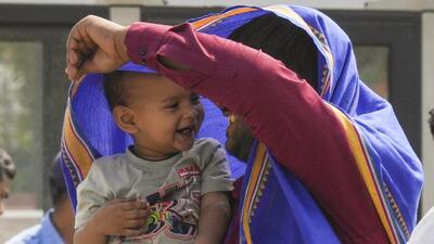 A father shields his child with a scarf from the scorching heat in New Delhi. (PTI Photo)