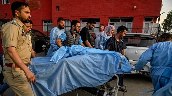 Paramedics and police personnel carry an injured tourist at a hospital in Anantnag, south of Srinagar, on Tuesday, following an attack. (AFP)