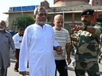 Border Security Force (BSF) soldier (R) gestures as Pakistan citizens return to their country through the India-Pakistan Wagah border post, about 35kms from Amritsar on April 24, 2025. 