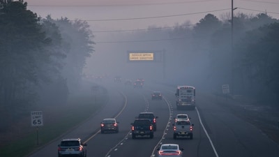 People drive on the Garden State Parkway as a matrix sign warns of smoke conditions on April 24, 2025, in New Jersey. (Getty Images via AFP)