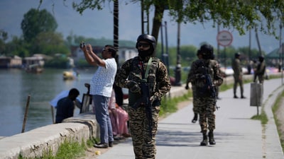 Soldiers guard as a tourist takes a picture with his cell phone on the banks of Dal Lake in Srinagar on April 24, 2025. (AP) Soldiers guard as a tourist takes a picture with his cell phone on the banks of Dal Lake in Srinagar on April 24, 2025. (AP)