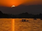 Tourists taking a ‘shikara’ ride are silhouetted against the setting Sun at the Dal Lake, in Srinagar(PTI)