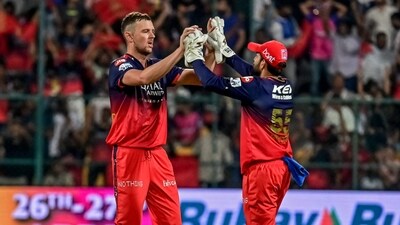 Royal Challengers Bengaluru's Josh Hazlewood (L) celebrates with teammate Jitesh Sharma after taking the wicket of Rajasthan Royals' Shimron Hetmyer. (AFP) Royal Challengers Bengaluru's Josh Hazlewood (L) celebrates with teammate Jitesh Sharma after taking the wicket of Rajasthan Royals' Shimron Hetmyer. (AFP)