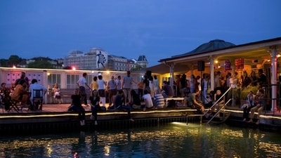 Sip on a handcrafted cocktail at Barfussbar while enjoying stunning views of Zurich’s Old Town.