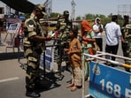 A military personnel with Border Security Force checks the passports of Pakistani citizens as they prepare to leave India.
