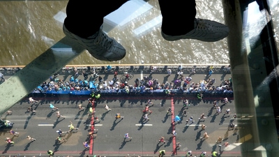 Visitors to Tower Bridge walk across the walkway as runners in the mass participation race go by during the TCS London Marathon, Sunday April 27, 2025. (Jonathan Brady/PA via AP) (AP) Visitors to Tower Bridge walk across the walkway as runners in the mass participation race go by during the TCS London Marathon, Sunday April 27, 2025. (Jonathan Brady/PA via AP) (AP)