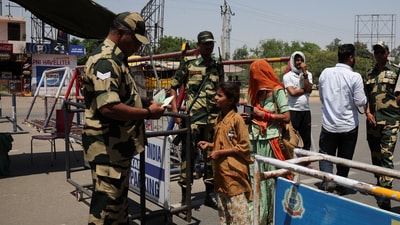 A military personnel with Border Security Force checks the passports of Pakistani citizens as they prepare to leave India. (REUTERS)