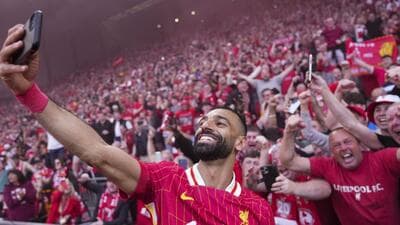 Liverpool's Mohamed Salah celebrates with the fans by taking a selfie after the Reds sealed the English Premier League title with a 5-1 win over Tottenham Hotspur at Anfield on Sunday. (AP)