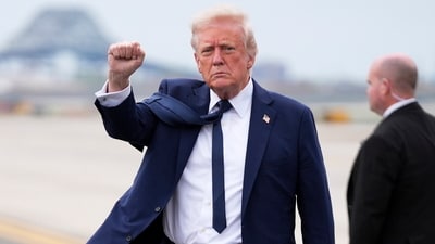 President Donald Trump gestures as he arrives at Newark Liberty International Airport in Newark, N.J., Saturday (AP)