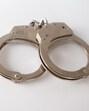 A high angle shot of metal handcuffs isolated on a white background