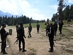 Security personnel inspect the site in the aftermath of an attack as food stall chairs lie empty in Pahalgam.