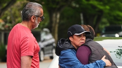 Esperanza Bermudez, center, who lives across the street from the scene, is comforted by friends Ronnie Claire, right, and Manjit Claire, the morning after a driver killed multiple people during a Filipino community festival Sunday, April 27, 2025, in Vancouver, British Columbia. (AP/PTI)(AP04_28_2025_000027B) (AP) Esperanza Bermudez, center, who lives across the street from the scene, is comforted by friends Ronnie Claire, right, and Manjit Claire, the morning after a driver killed multiple people during a Filipino community festival Sunday, April 27, 2025, in Vancouver, British Columbia. (AP/PTI)(AP04_28_2025_000027B) (AP)
