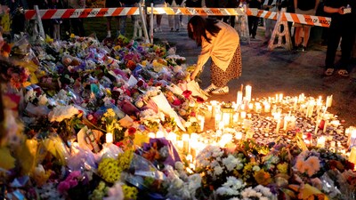 A woman leaves flowers as community members gather to mourn together, the day after a vehicle drove into a crowd at a Filipino community Lapu Lapu day block party, in Vancouver, Canada April 27, 2025. REUTERS/David Ryder     TPX IMAGES OF THE DAY (REUTERS)