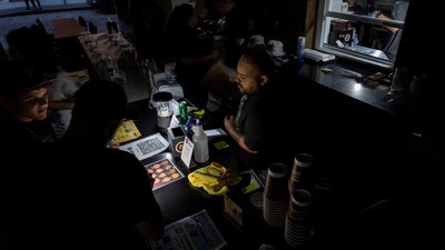 A client lights up the menu of a restaurant with a cell phone light after Puerto Rico was hit with a massive power outage where energy plants across the island unexpectedly shut down, in San Juan, Puerto Rico April 16, 2025.  REUTERS/Ricardo Arduengo (REUTERS)